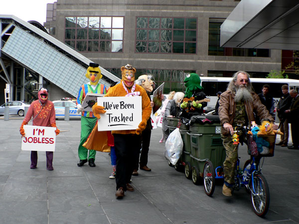 Joey Skaggs Pedals his Mobile Homeless Home Accompanied by Band of Pissed-off Muppets to Goldman Sachs Office in New York, 2012