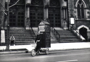 Father Anthony Joseph, aka Joey Skaggs, Pedals Portofess, his Mobile Confessional Booth, to Democratic Convention, 1992